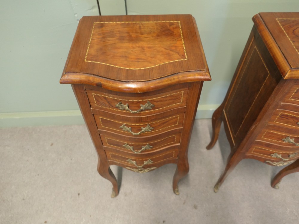 A pair of tall French walnut bedside lockers featuring four inlaid drawers, curved cabriole legs, and gilded brass ormolu mounts. View V