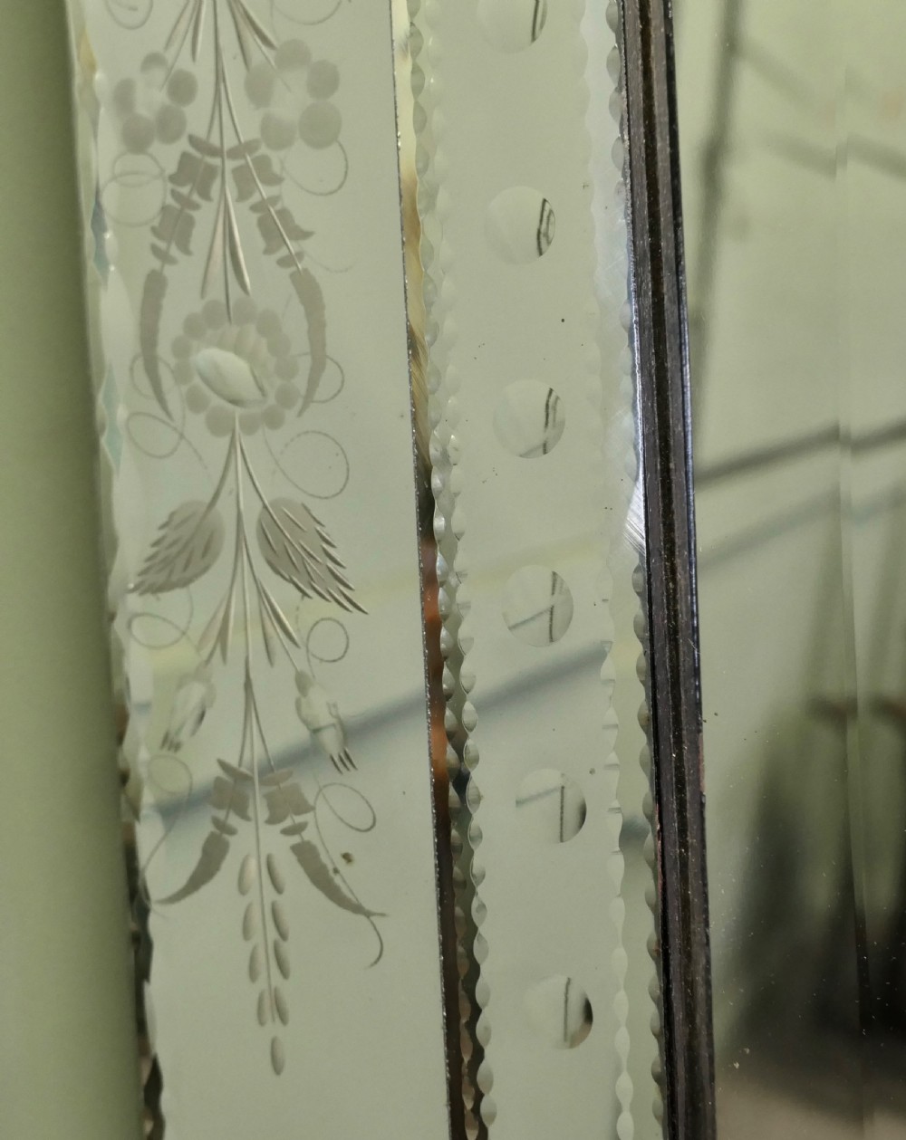A tall Art Deco Venetian wall mirror featuring hand-etched floral motifs, a contoured crest, and bevelled border panels. View V