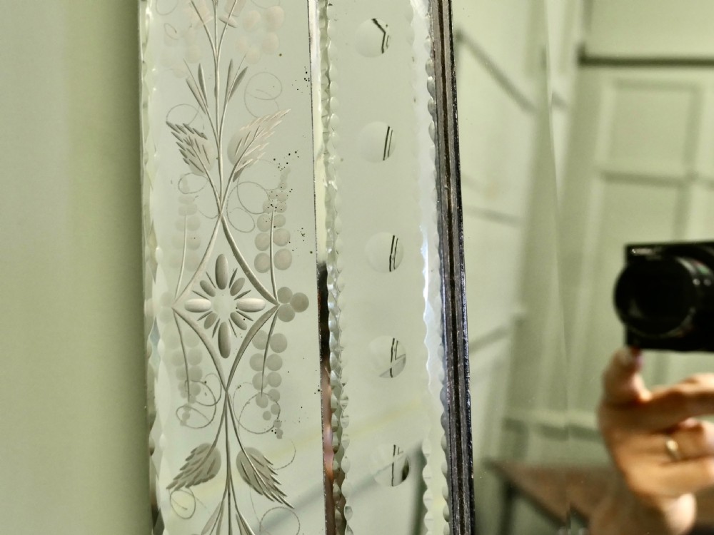 A tall Art Deco Venetian wall mirror featuring hand-etched floral motifs, a contoured crest, and bevelled border panels. View VI
