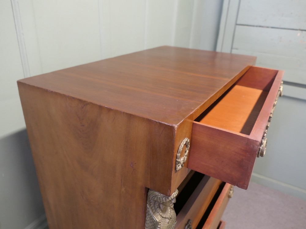 A tall French Empire style walnut chest of drawers featuring decorative metal mounts, caryatid corner figures, swan motifs, and claw feet. View VI