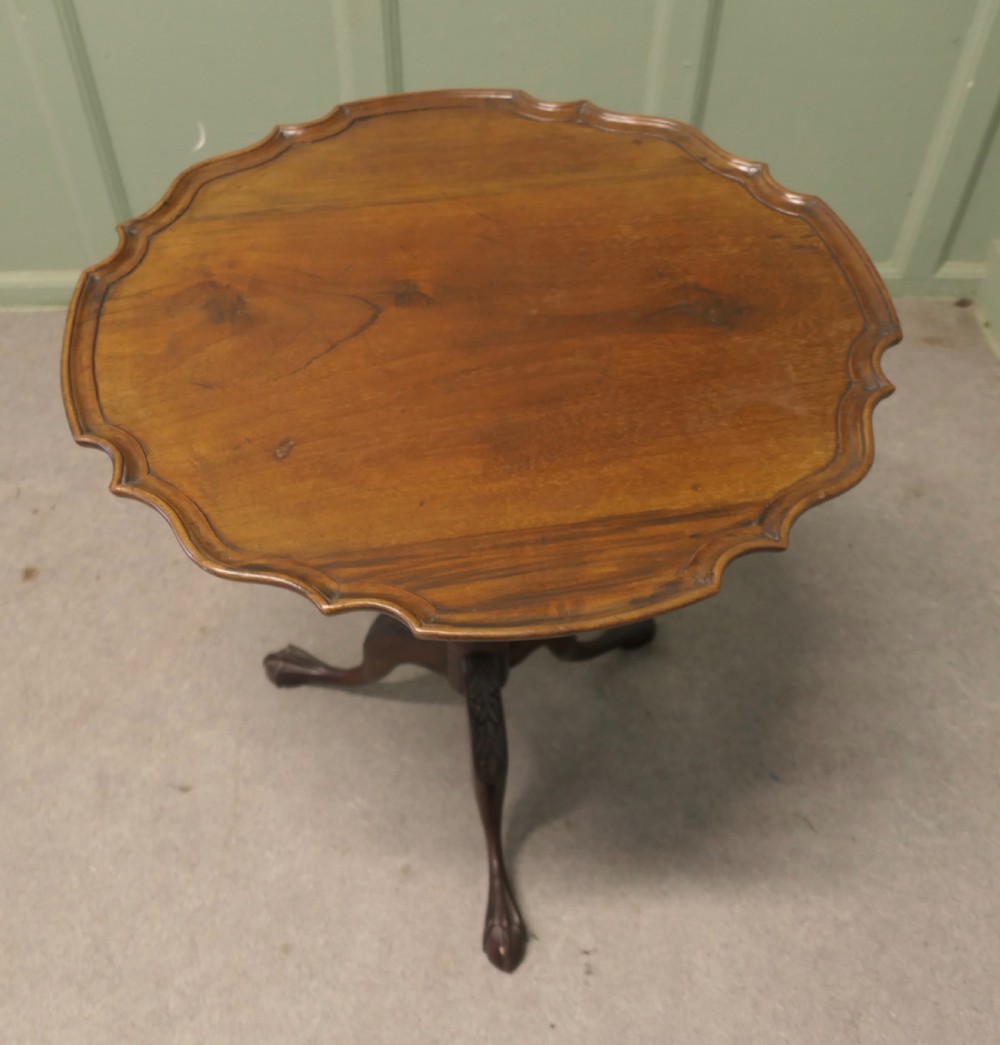 A 19th-century mahogany tilt-top wine table featuring a scalloped piecrust edge, turned central column, and carved tripod legs with claw feet. View IV