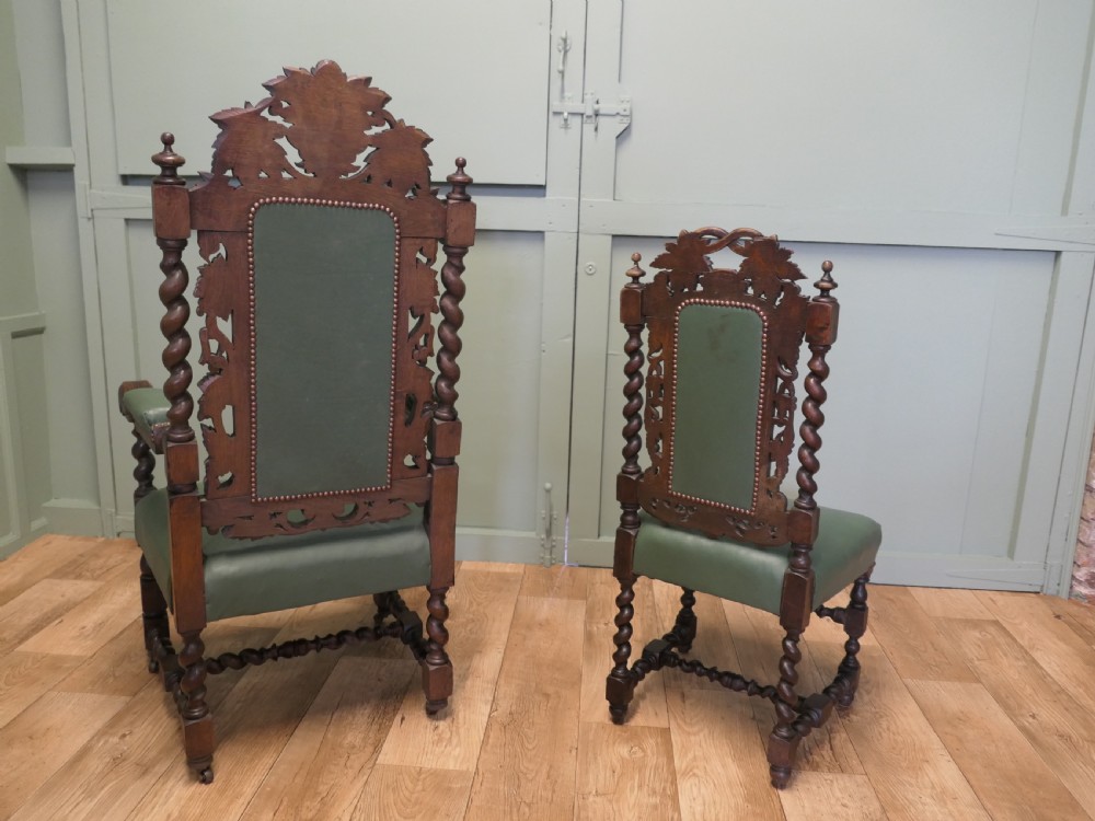A set of ten carved oak dining chairs featuring green leather upholstery, barley twist legs, and detailed crest rails, comprising two carver armchairs and eight side chairs. View VII