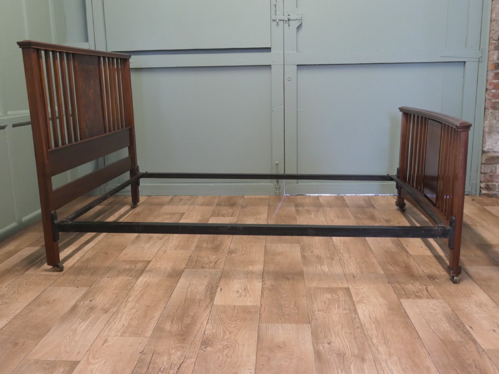 An Edwardian burr walnut double bed frame featuring a slatted headboard and footboard centered with figured walnut panels, supported by iron side rails. View V