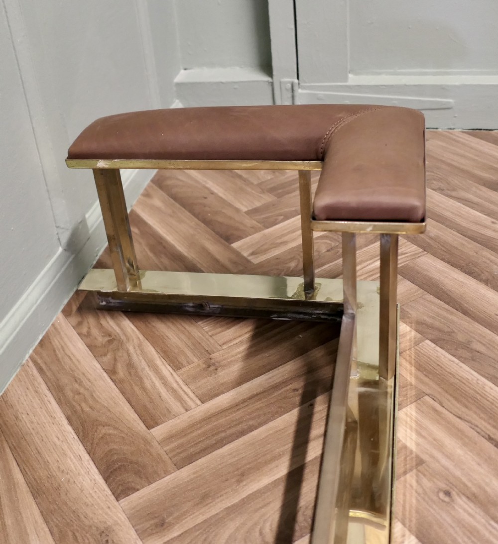 An Art Deco polished brass club fender with square upright supports and brown leather corner seats. View VI
