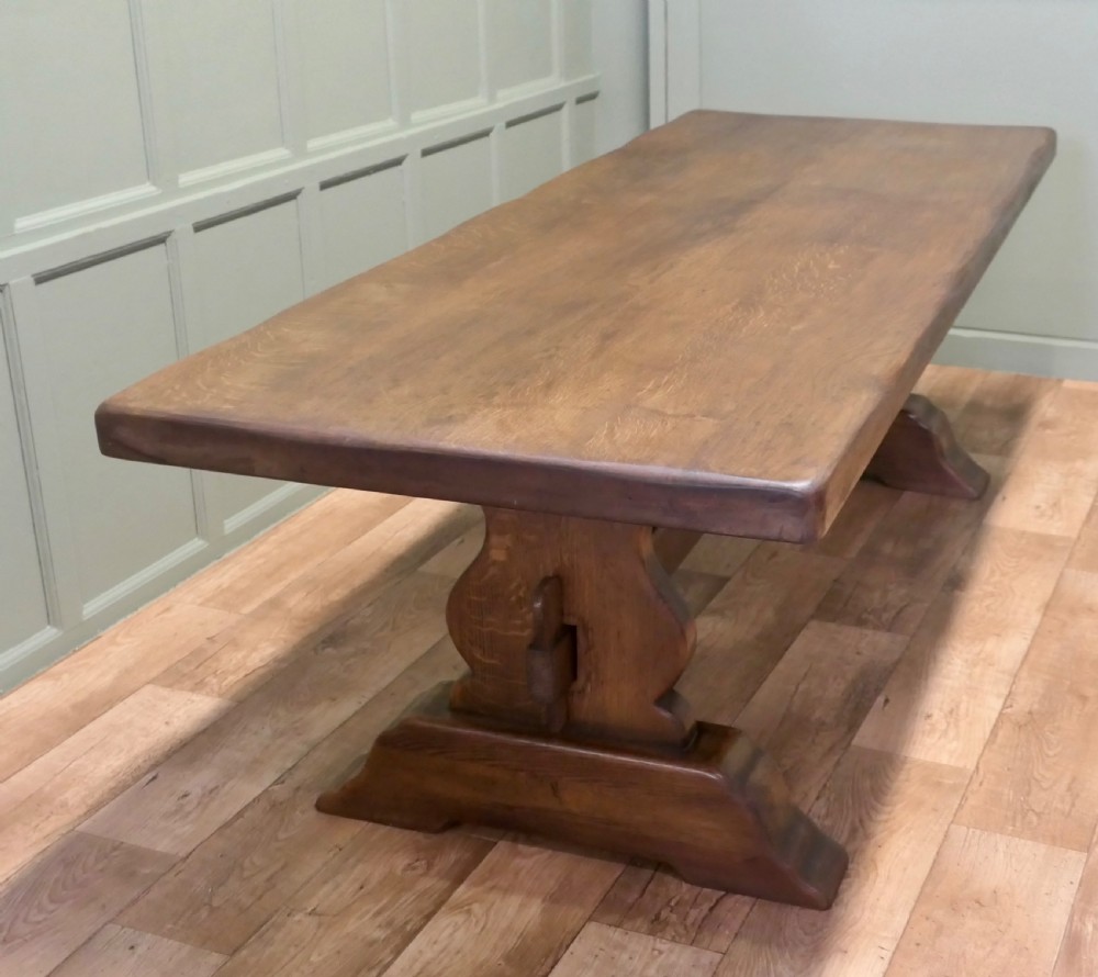 A large 19th-century French oak refectory table featuring a solid plank top, shaped trestle ends, and a central connecting stretcher. View IV