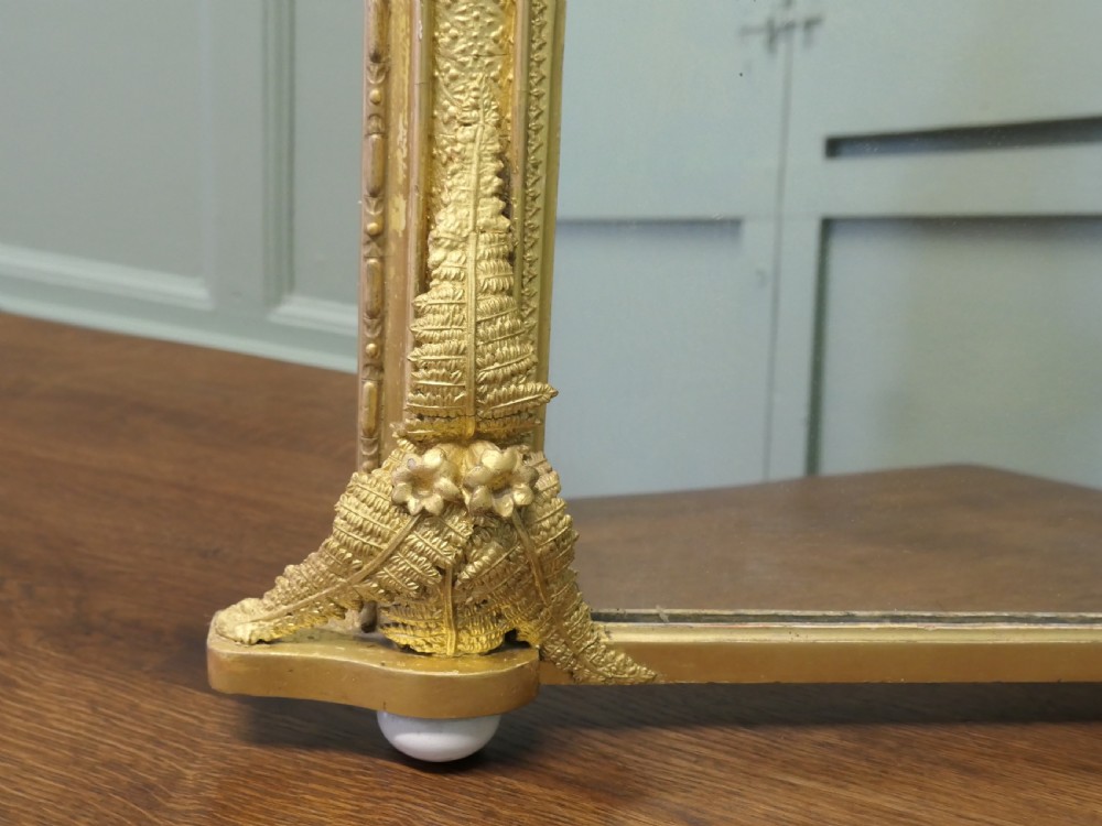 An arched gold giltwood overmantel mirror with fern leaf cresting and small corner feet. View IV