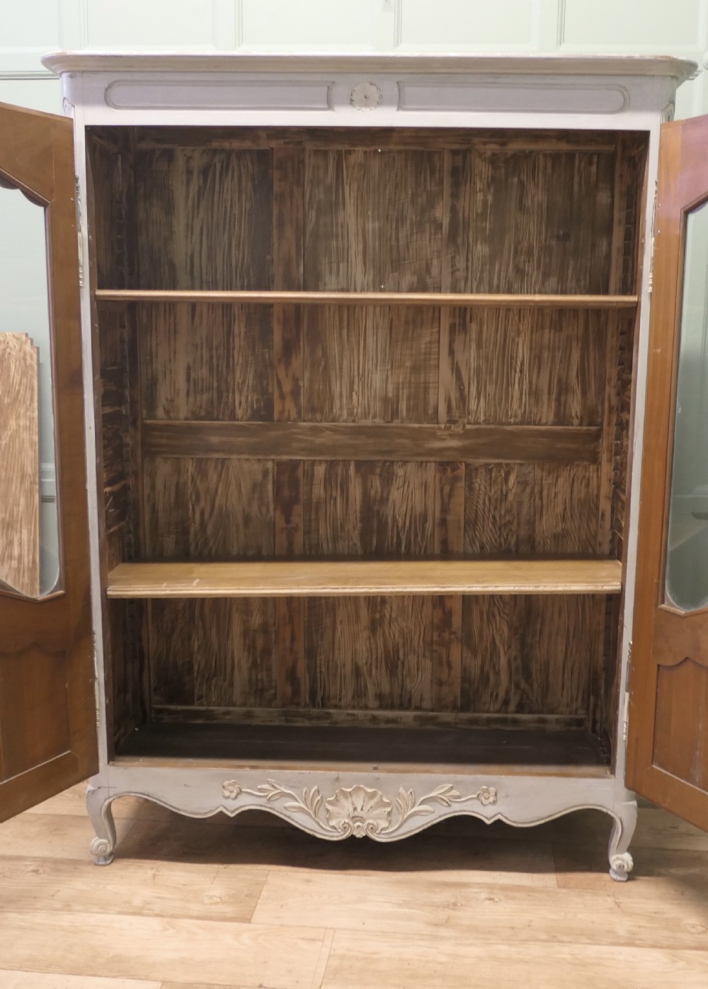 A double-door painted wooden vitrine featuring glazed upper panels with serpentine framing, carved shell lower mouldings, and cabriole legs. View VI
