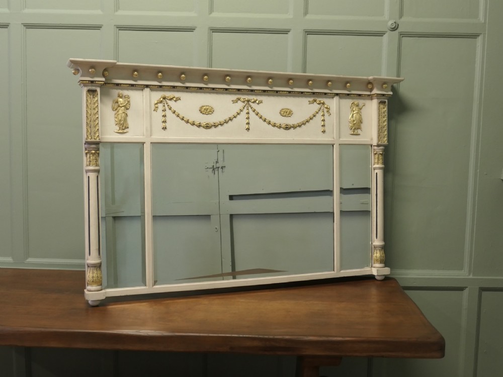 A Regency Neoclassical triple-plate overmantel mirror with off-white painted frame, gold leaf swags, relief figures, and side pilasters.