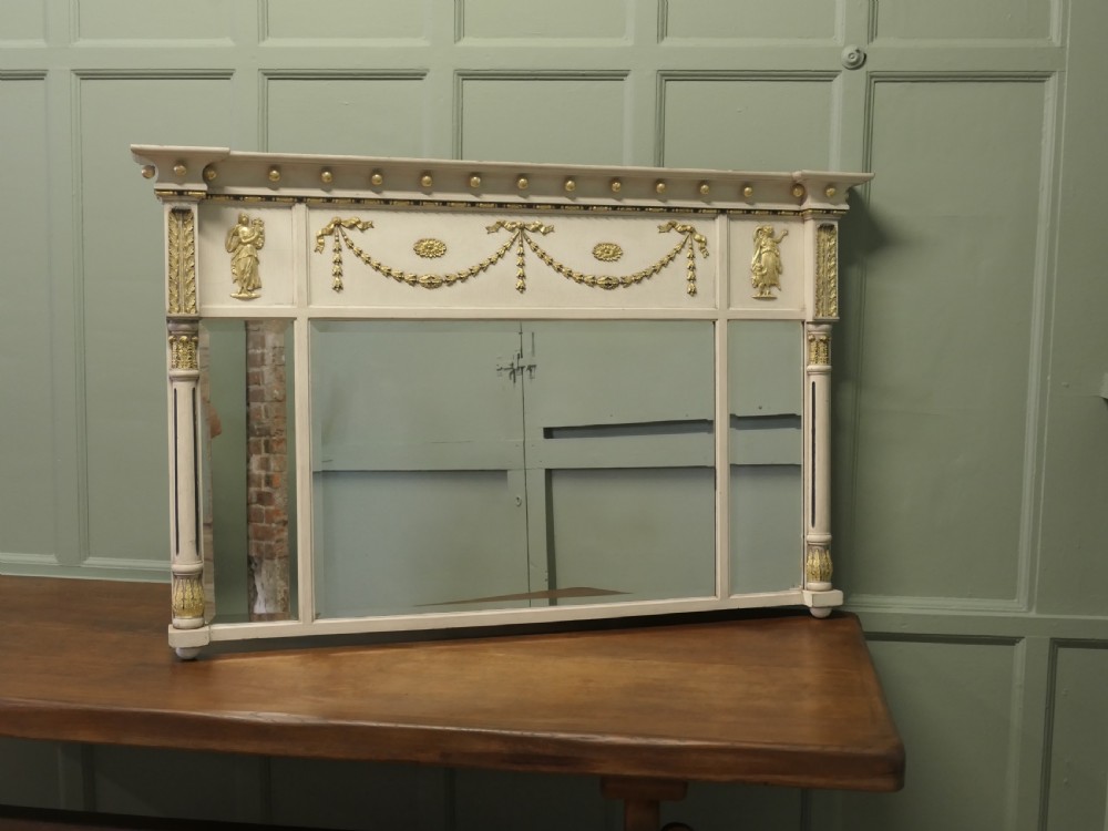 A Regency Neoclassical triple-plate overmantel mirror with off-white painted frame, gold leaf swags, relief figures, and side pilasters. View II
