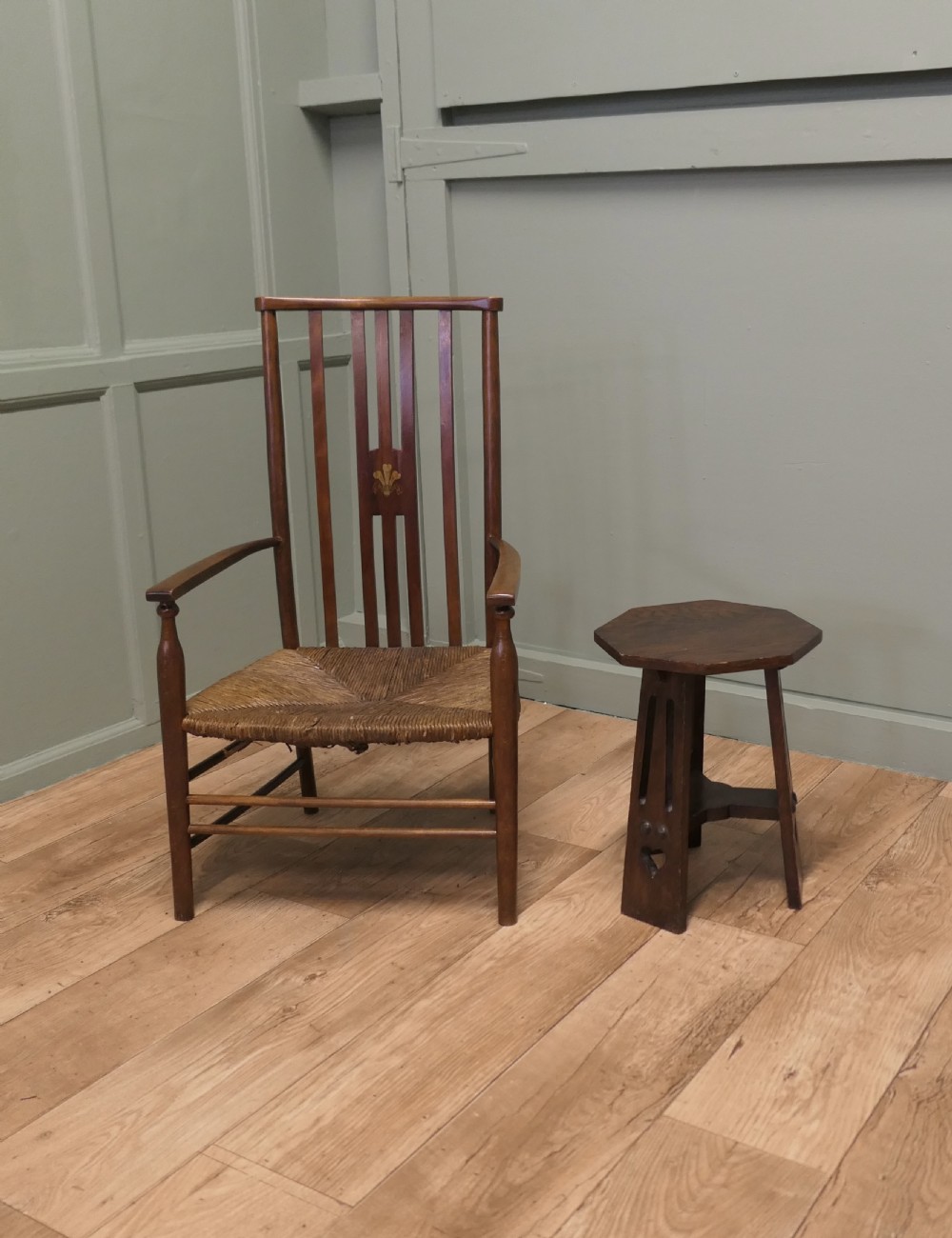 An Arts and Crafts wooden side table featuring a hexagonal top, three shaped legs with pierced cutouts, and a lower triangular stretcher. View VI