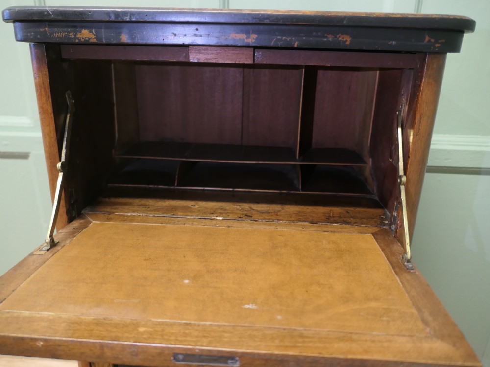 A Victorian burr walnut music filing cabinet featuring a fall-front upper compartment with inlaid details, a central drawer, and double glazed lower doors. View V