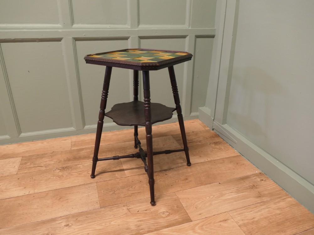 An Arts and Crafts dark wood side table with a chequerboard top made of green and yellow glazed ceramic tiles, turned legs, and an undertier. View IV