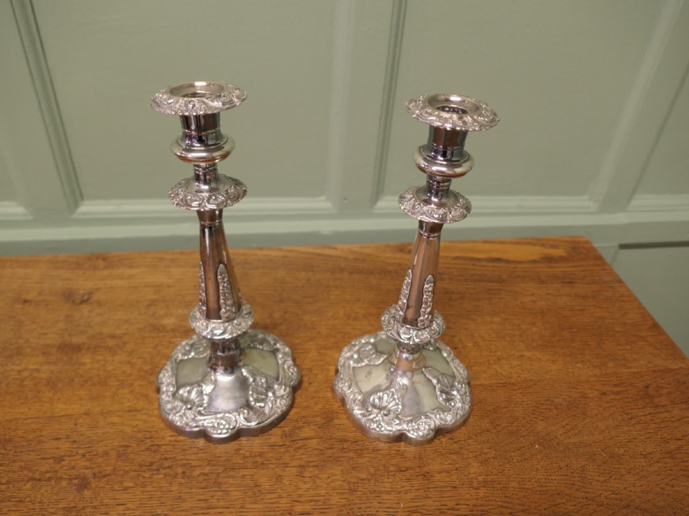 A pair of 19th-century silver-plated candlesticks featuring floral relief details on the shaped bases and tapered stems. View III