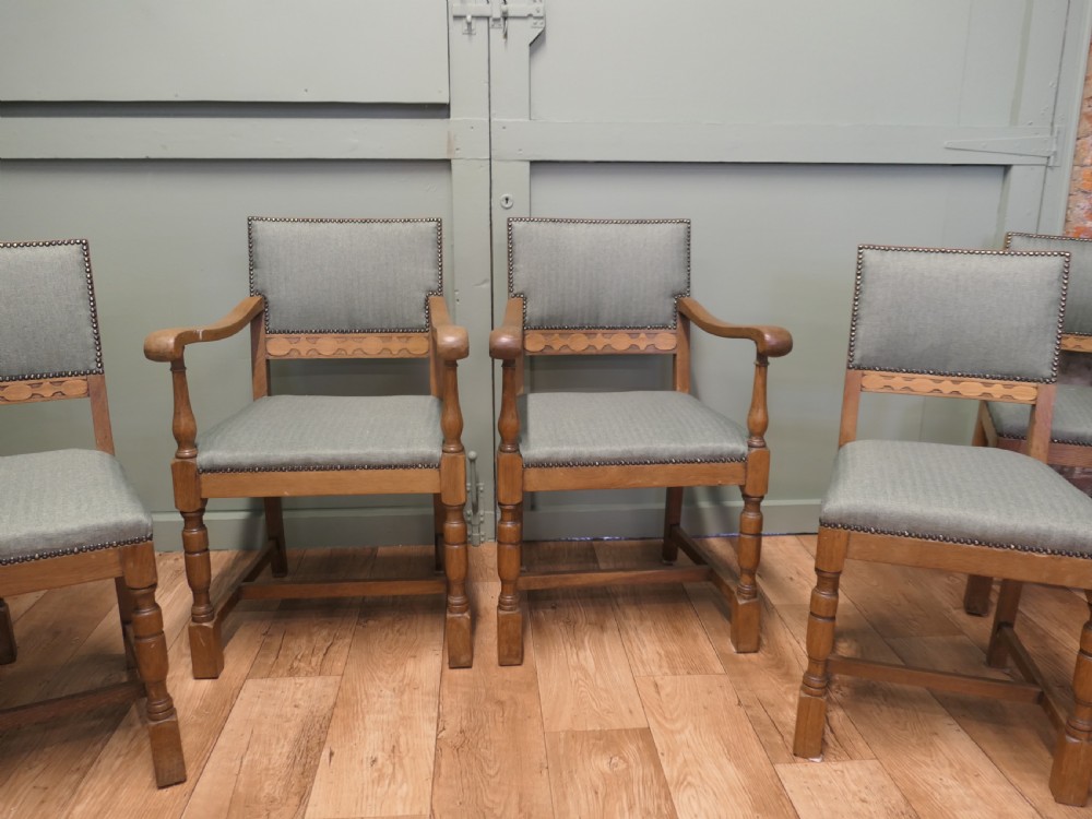 A set of eight Arts and Crafts golden oak dining chairs with upholstered seats and backrests trimmed with brass studs. View III