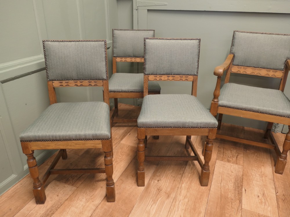 A set of eight Arts and Crafts golden oak dining chairs with upholstered seats and backrests trimmed with brass studs. View IV