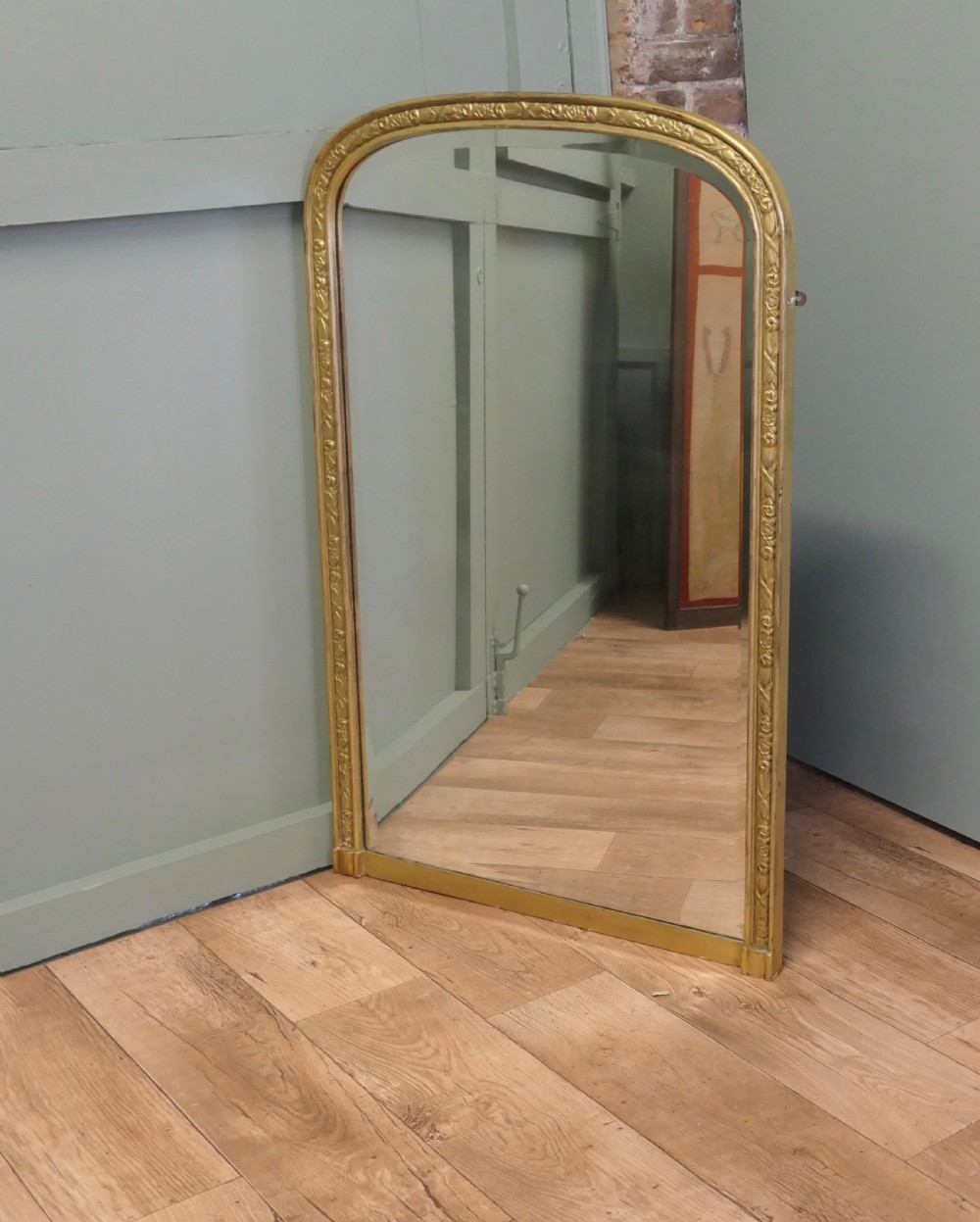 A tall 19th-century French Louis Philippe wall mirror featuring rounded upper corners and an engraved gold gilded frame. View V