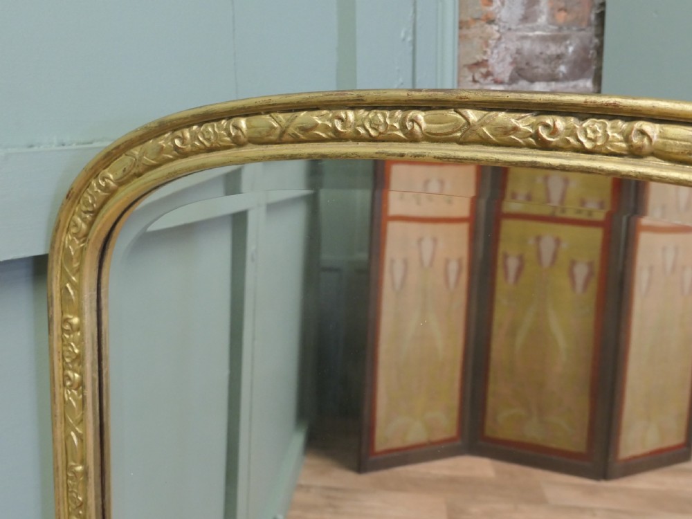 A tall 19th-century French Louis Philippe wall mirror featuring rounded upper corners and an engraved gold gilded frame. View VI