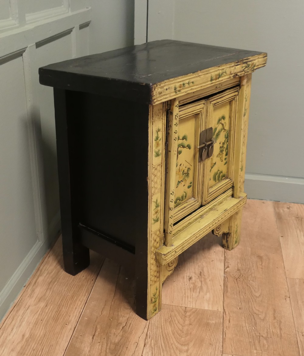 A nineteenth-century cream painted wooden Chinoiserie cabinet featuring two doors illustrated with Asian figures, foliage, decorative borders, and a brass pin closure. View IV