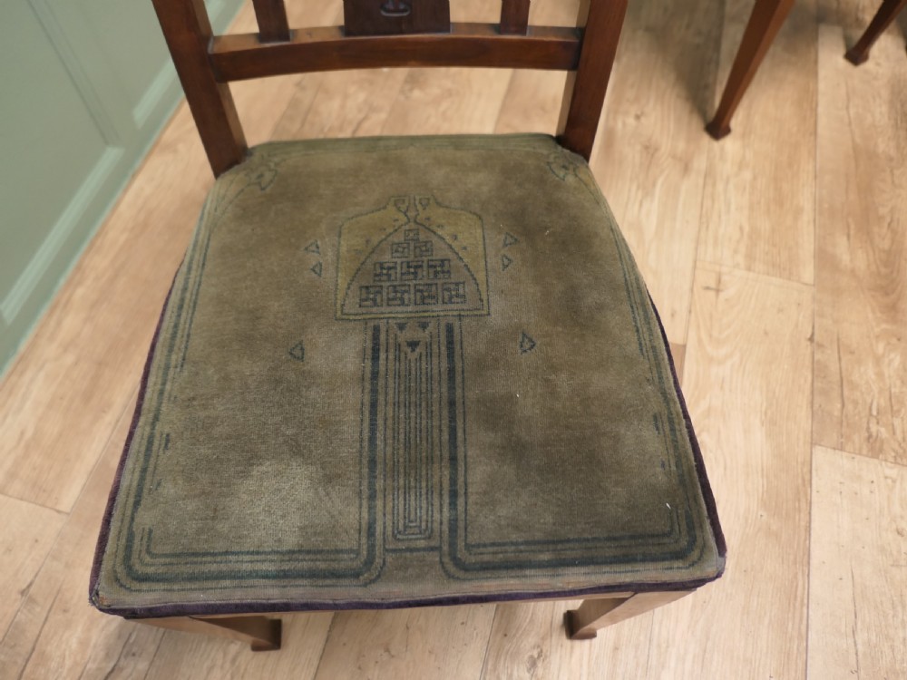 A set of six golden oak Arts and Crafts dining chairs featuring vertical slatted backs with top rail cutouts and dark green upholstered seats. View IV