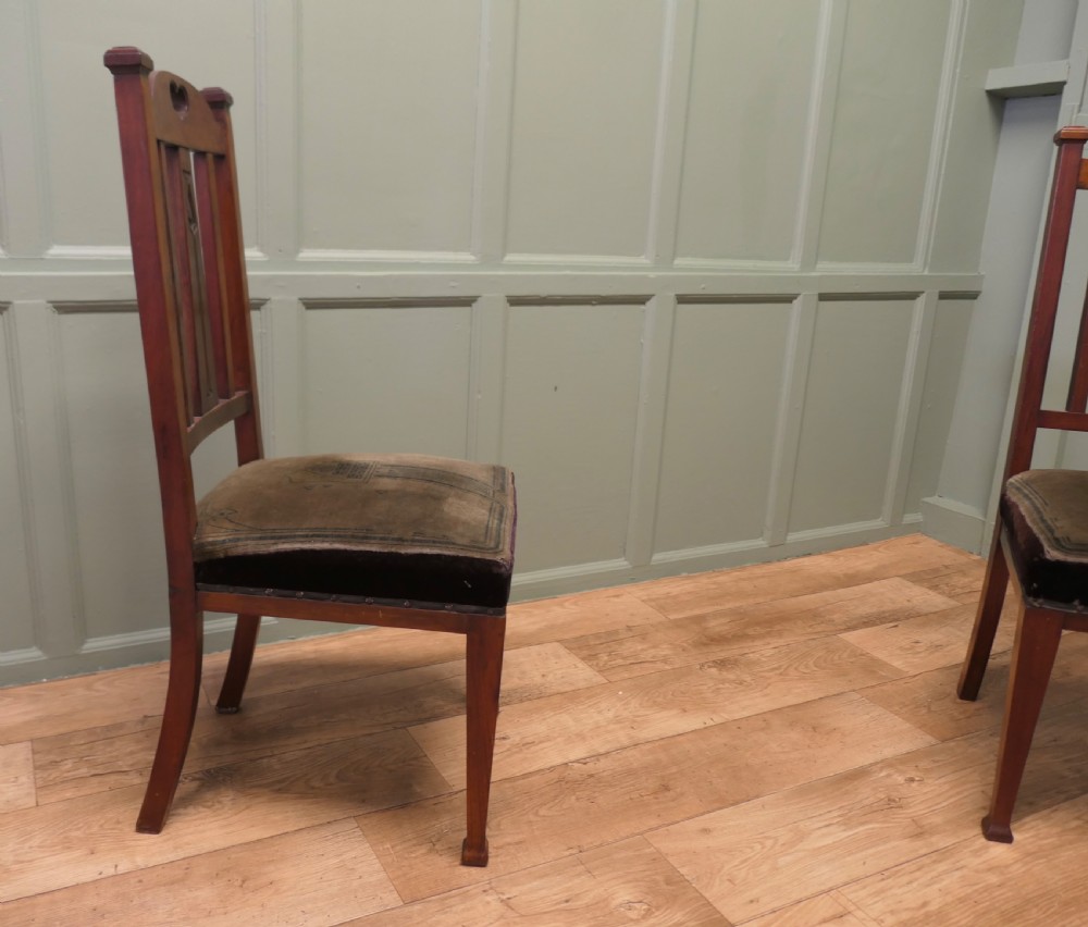 A set of six golden oak Arts and Crafts dining chairs featuring vertical slatted backs with top rail cutouts and dark green upholstered seats. View V