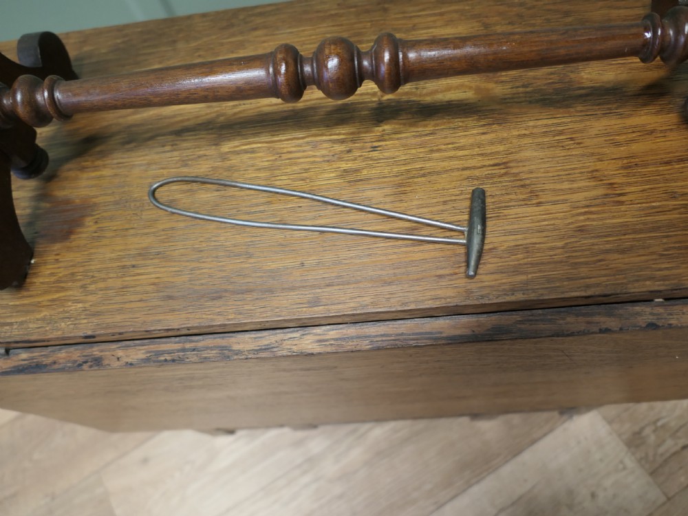 A Victorian carved walnut rack displaying six tuned brass bells arranged across two horizontal tiers on turned wooden uprights. View II