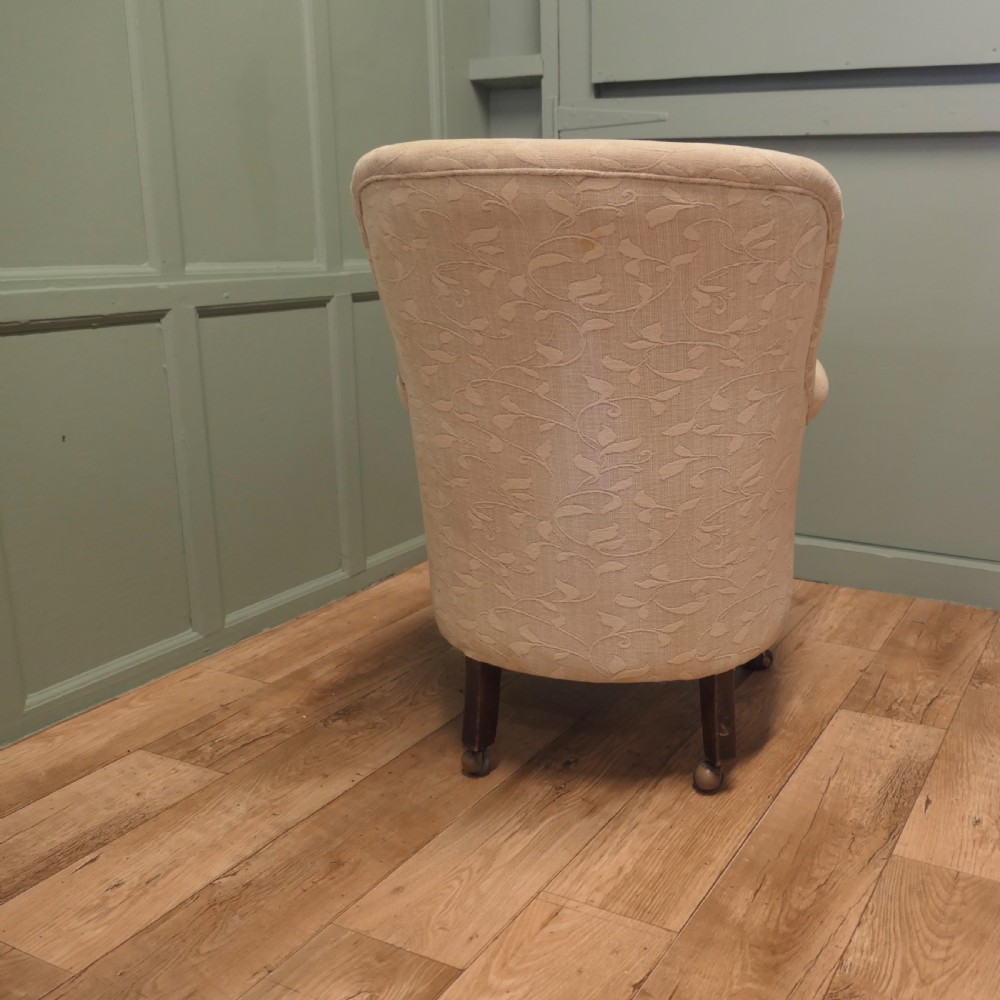 A Victorian upholstered tub armchair in cream patterned fabric with carved timber legs. View VI