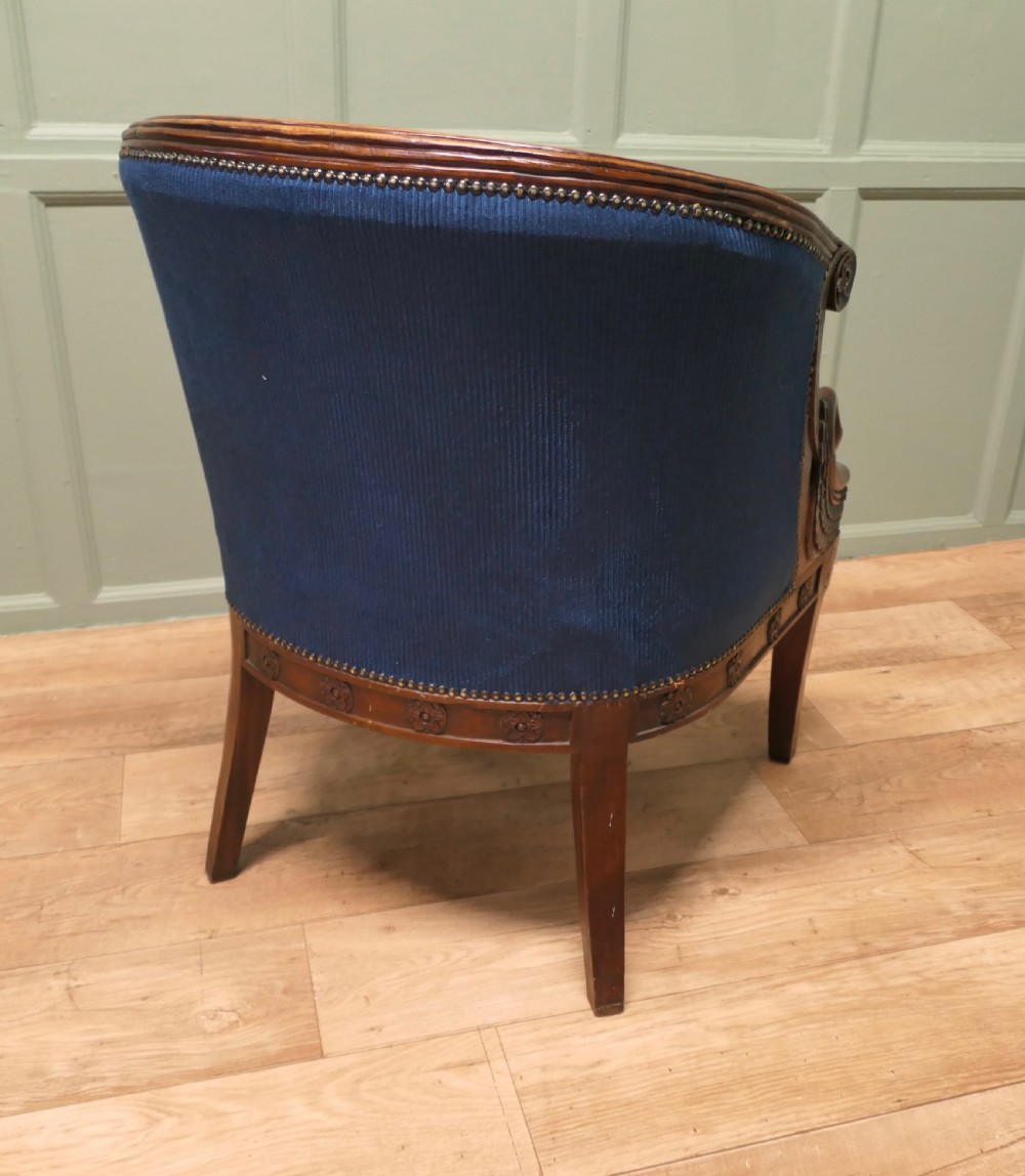 A pair of Victorian tub chairs with blue upholstery and carved mahogany frames featuring carved swan neck armrests. View VI