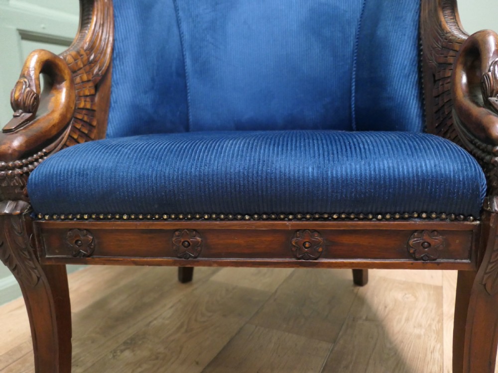 A pair of Victorian tub chairs with blue upholstery and carved mahogany frames featuring carved swan neck armrests. View VII