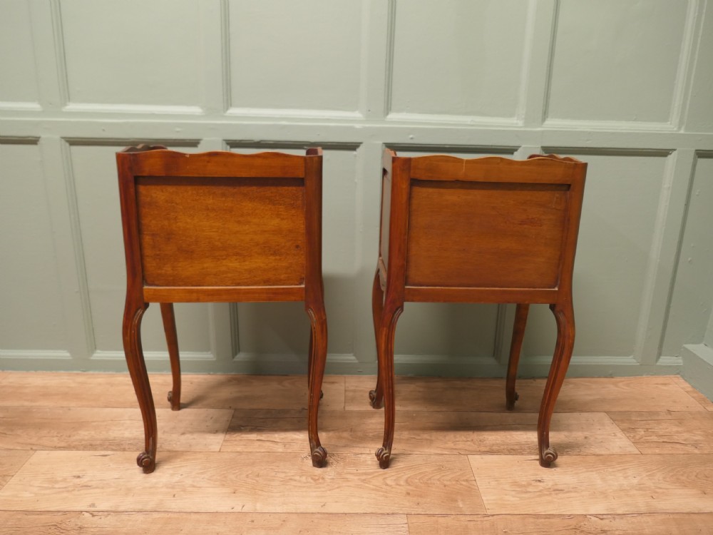 A pair of French cherry wood bedside tables featuring cabriole legs, brass handles, and carved shell motifs, one configured with an open shelf and the other with three drawers. View IV