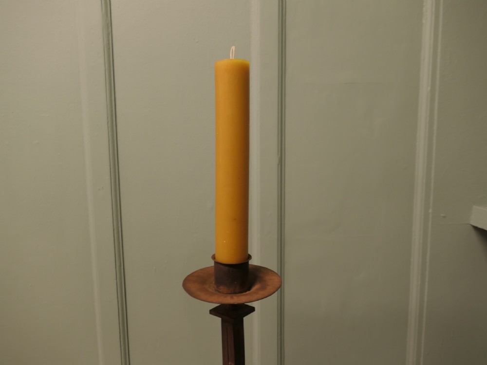 A tall hand-forged wrought iron floor candlestick with a twisted central stem, collar joins, a drip tray sconce, and a splayed tripod base. View II