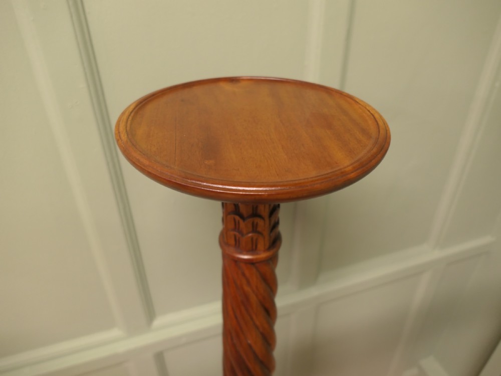 A pair of tall carved mahogany torchere stands featuring spiral shafts, foliate carving, and tripod cabriole bases. View VI