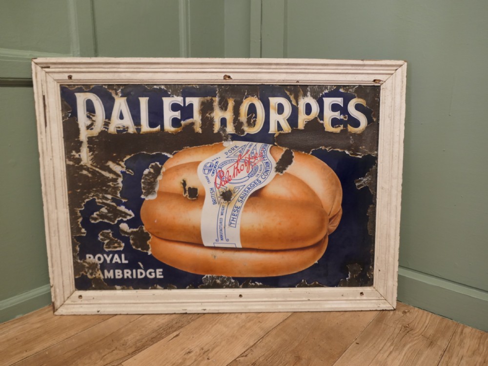 A framed antique blue and white enamel advertising sign for Palethorpes Royal Cambridge sausages featuring a central pictorial illustration.