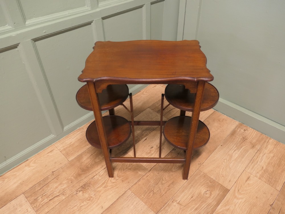 An Edwardian mahogany side table featuring a flat rectangular top and two side-mounted folding circular tiered cake stands. View II