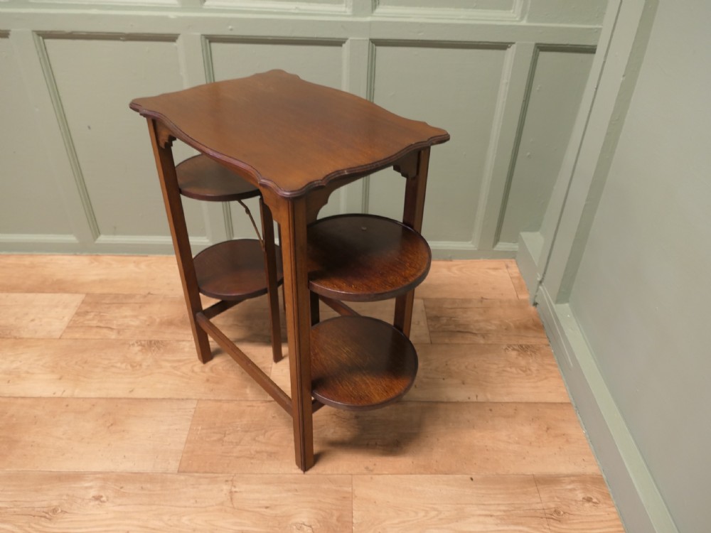 An Edwardian mahogany side table featuring a flat rectangular top and two side-mounted folding circular tiered cake stands. View IV