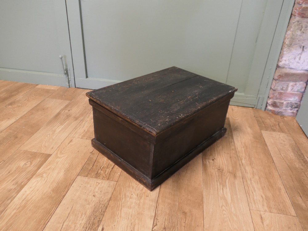 A rectangular dark stained pine carpenters box with a hinged lid and a moulded plinth base. View III