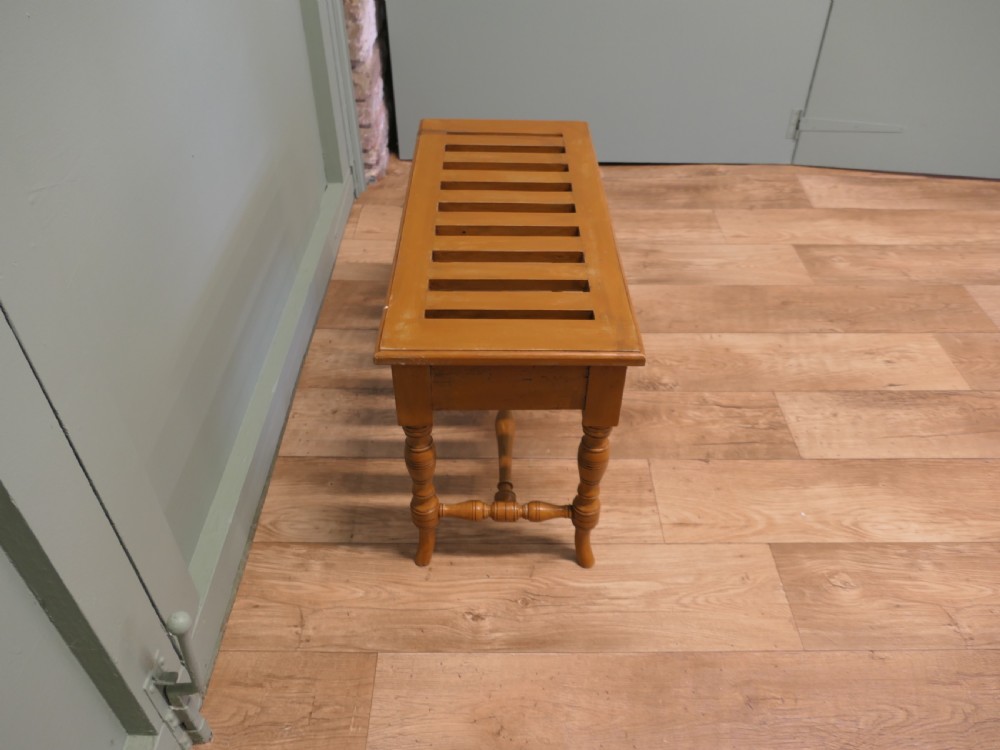 A golden oak Arts and Crafts luggage rack featuring a slatted top surface, turned legs, and a turned central stretcher. View IV