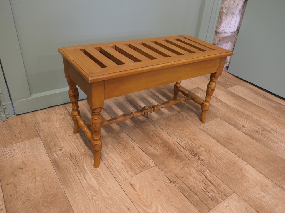 A golden oak Arts and Crafts luggage rack featuring a slatted top surface, turned legs, and a turned central stretcher. View VI
