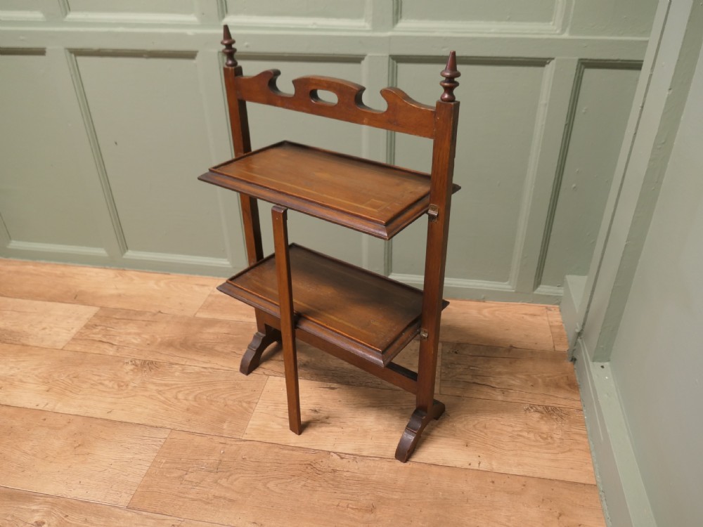 A warm brown mahogany metamorphic fire screen featuring turned finials that transforms into a two-tiered occasional butler table. View III