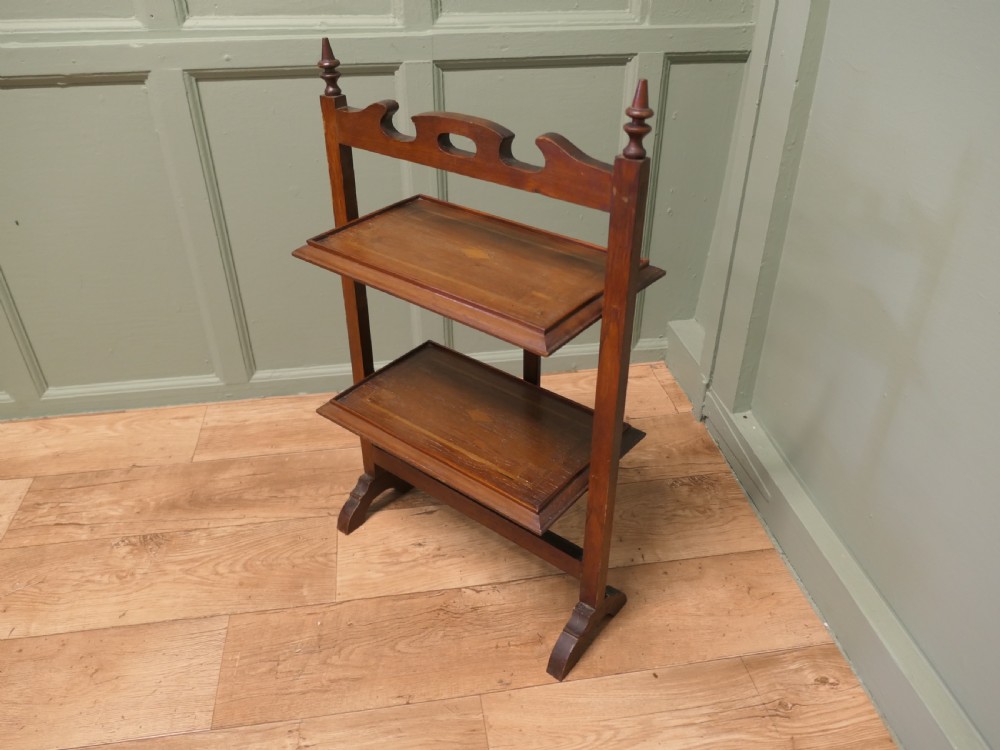 A warm brown mahogany metamorphic fire screen featuring turned finials that transforms into a two-tiered occasional butler table. View IV