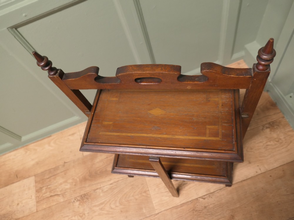 A warm brown mahogany metamorphic fire screen featuring turned finials that transforms into a two-tiered occasional butler table. View V