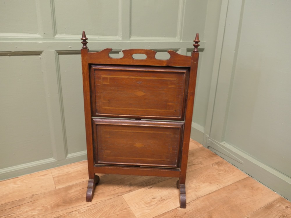 A warm brown mahogany metamorphic fire screen featuring turned finials that transforms into a two-tiered occasional butler table. View VI