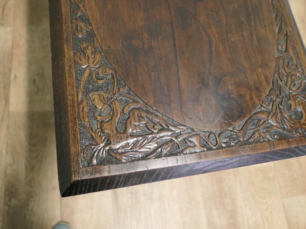 A rectangular dark elm side table featuring intricately carved Celtic scrollwork along the apron and tabletop border, supported by turned legs. View II
