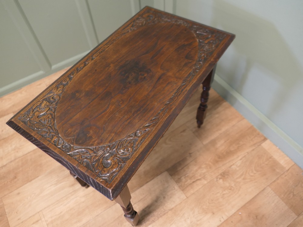 A rectangular dark elm side table featuring intricately carved Celtic scrollwork along the apron and tabletop border, supported by turned legs. View IV