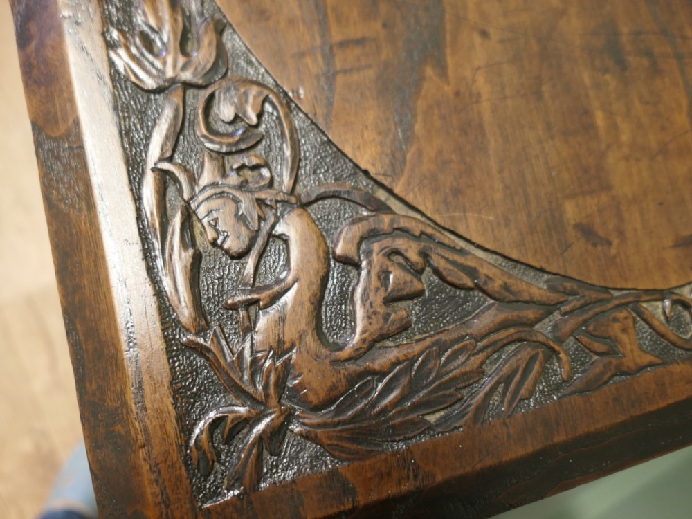 A rectangular dark elm side table featuring intricately carved Celtic scrollwork along the apron and tabletop border, supported by turned legs. View V