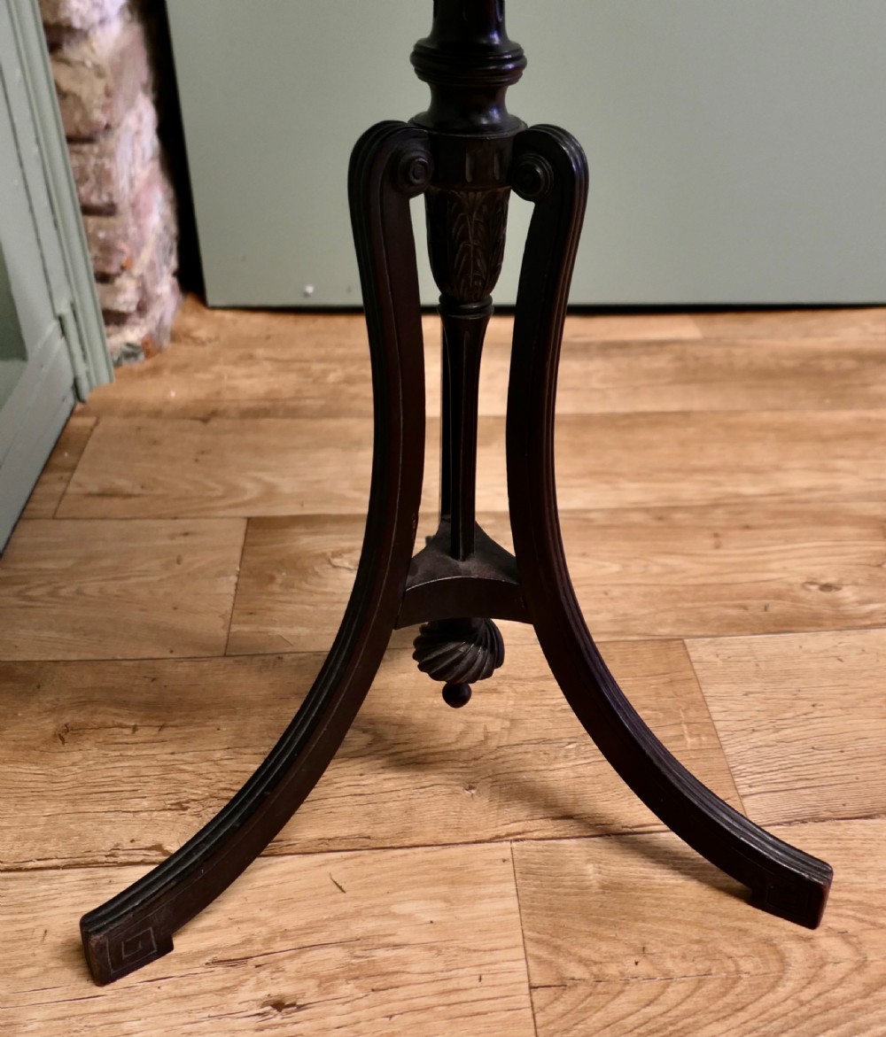 A dark mahogany Art Nouveau wine table featuring a carved circular top, turned stem, and three swept legs with a carved central pendant. View II