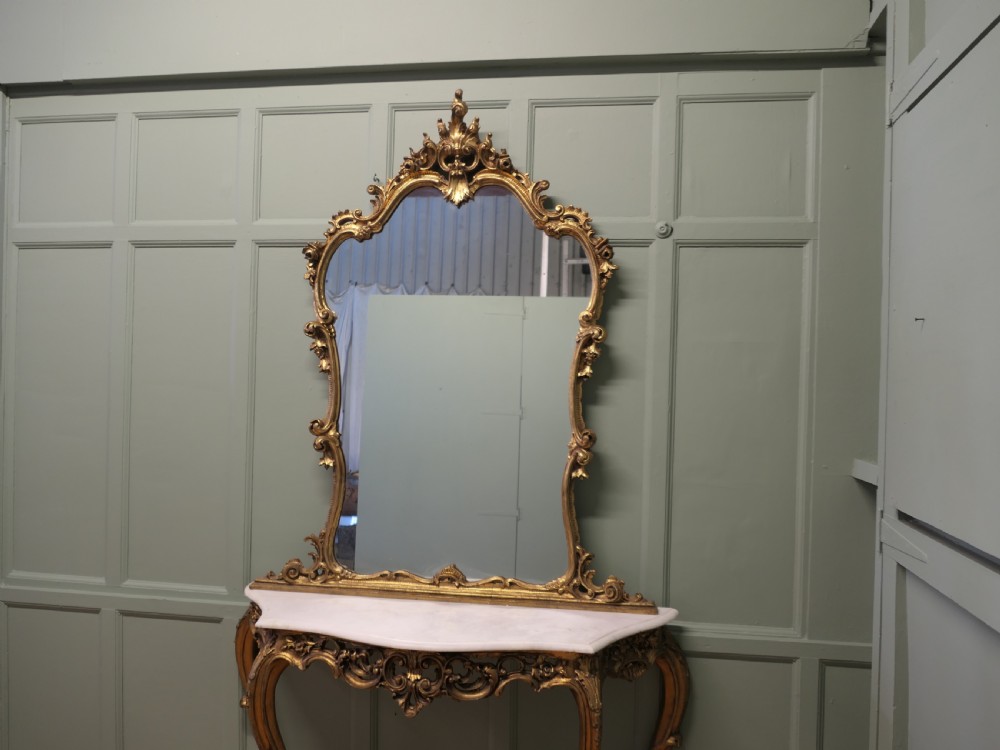 A 19th-century Italian giltwood console table featuring an ornate carved frame, cabriole legs, a white marble top, and a matching gilt-framed wall mirror. View III