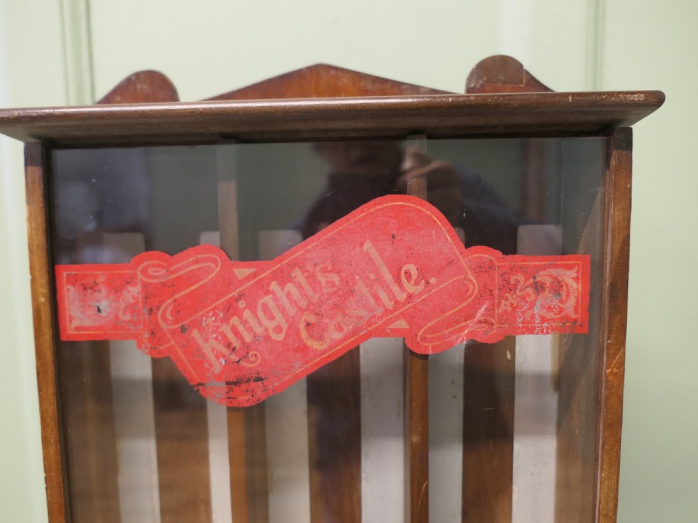 An antique wooden countertop soap dispensing cabinet featuring glazed panels, red Knights Castile branding, and three metal lower dispensing compartments. View II