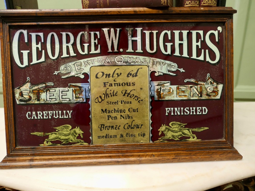 A Victorian mahogany shop counter display cabinet with a gilded reverse-painted glass panel advertising George W. Hughes steel pens. View VI