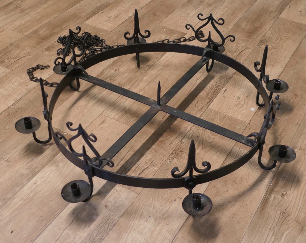 A large circular black wrought iron Gothic chandelier with candle sockets suspended by link chains. View VI