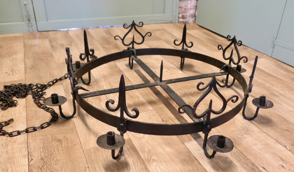 A large circular black wrought iron Gothic chandelier with candle sockets suspended by link chains. View VII